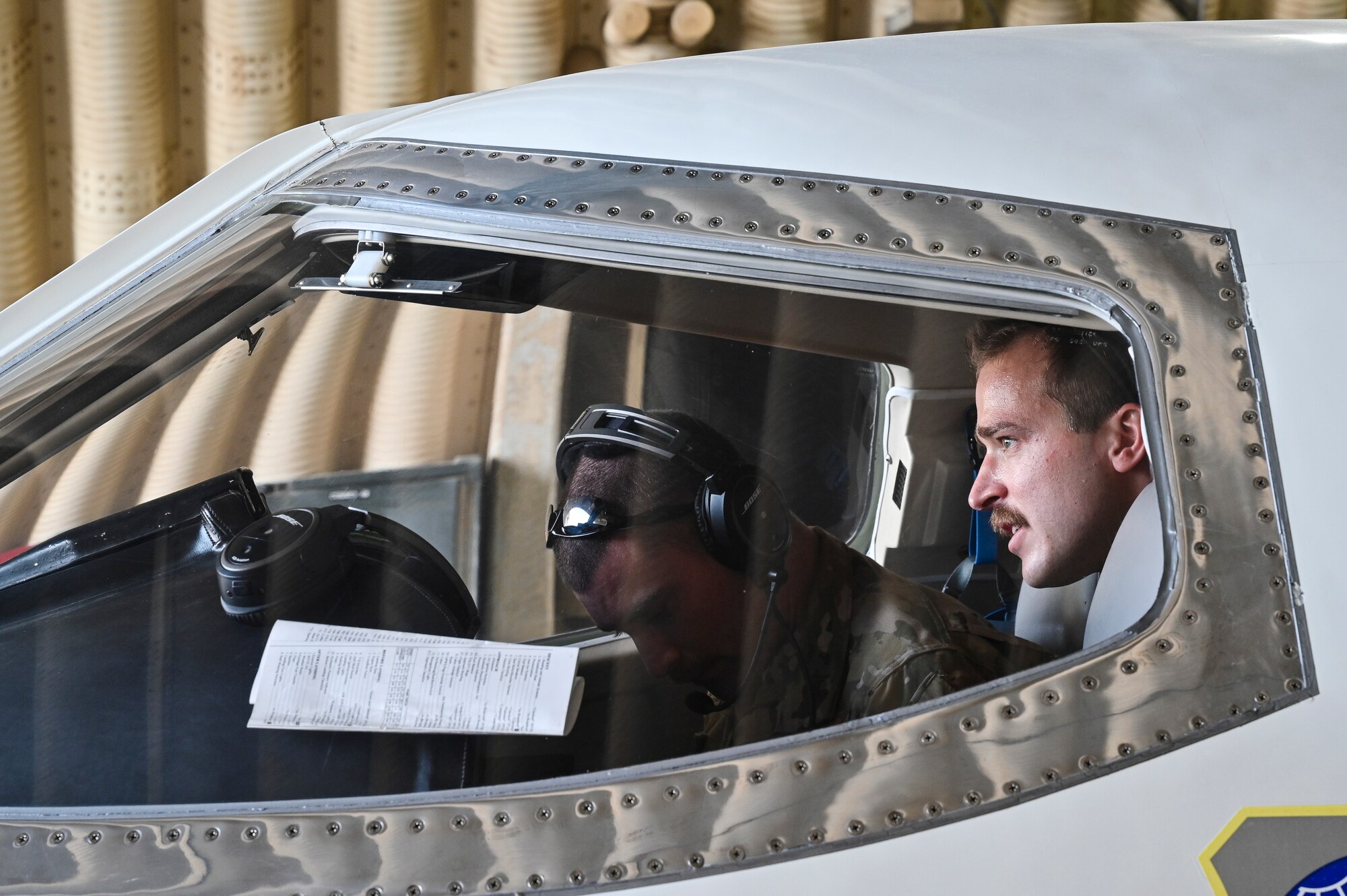 U.S. Air Force 1st Lt. Donald Snediker, right, and U.S. Air Force Capt. Greg Ihlenburg, pilots with the 746th Expeditionary Airlift Squadron deployed to Al Udeid Air Base, Qatar, prepare for a C-21 flight at AUAB, Feb. 24, 2020.