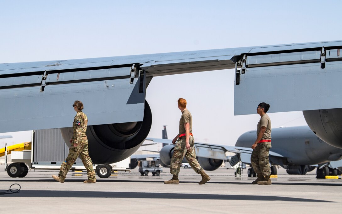 U.S. Air Force Capt. Kelsey Glover, left, a 28th Expeditionary Air Refueling Squadron pilot, and crew chiefs perform a preflight check on a U.S. Air Force KC-135 Stratotanker at Al Udeid Air Base, Qatar, March 17, 2020.