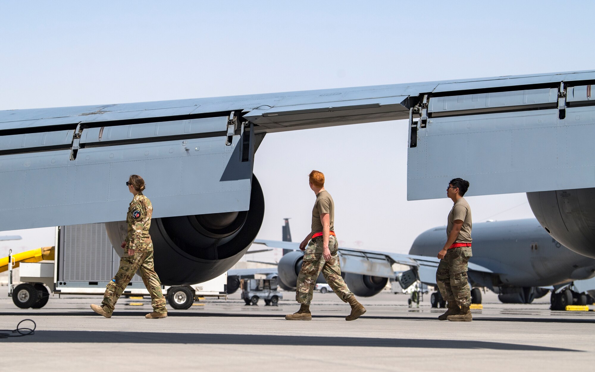 U.S. Air Force Capt. Kelsey Glover, left, a 28th Expeditionary Air Refueling Squadron pilot, and crew chiefs perform a preflight check on a U.S. Air Force KC-135 Stratotanker at Al Udeid Air Base, Qatar, March 17, 2020.