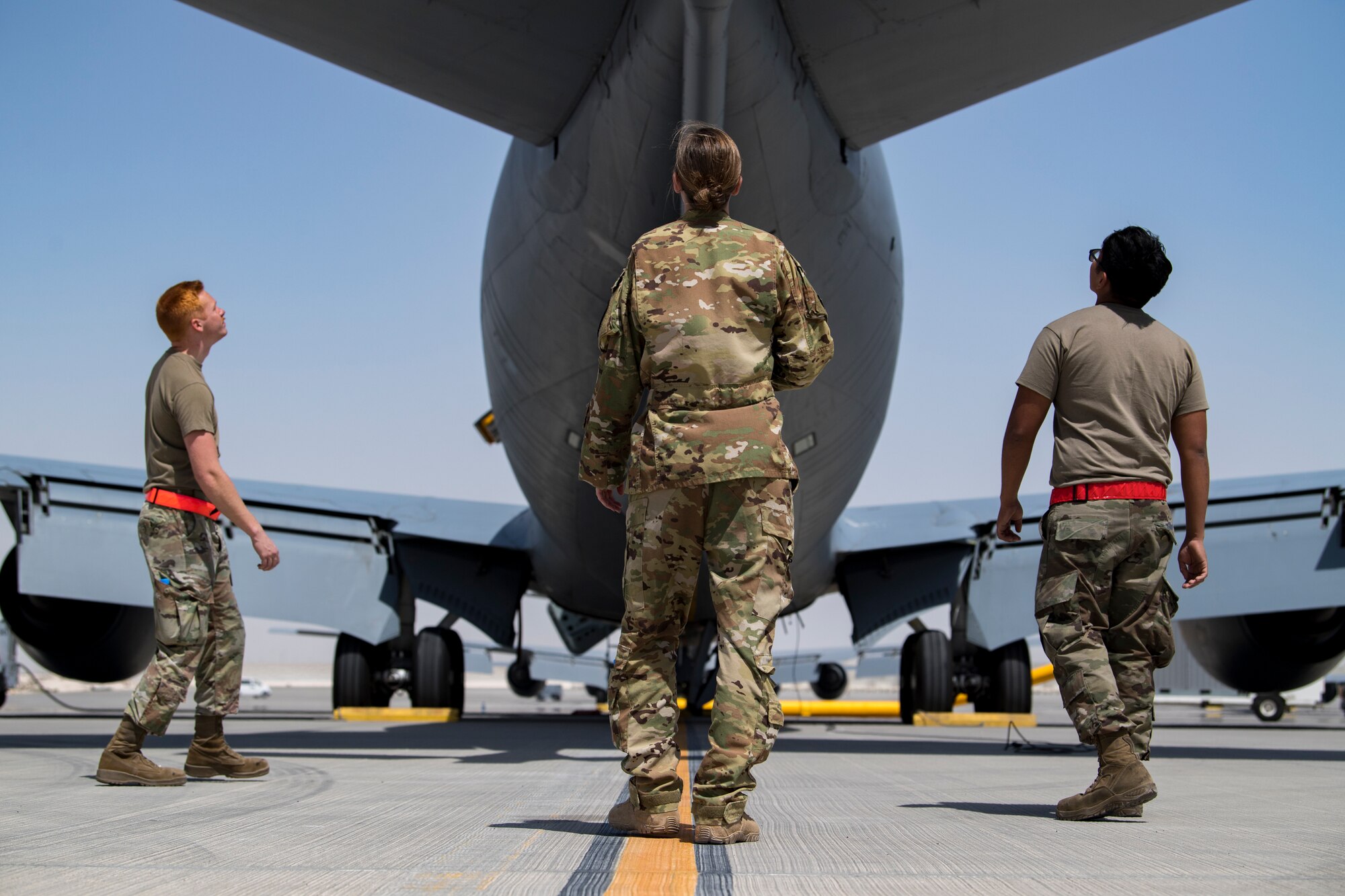 U.S. Air Force Capt. Kelsey Glover, middle, a 28th Expeditionary Air Refueling Squadron pilot, and crew chiefs perform a preflight check on a U.S. Air Force KC-135 Stratotanker at Al Udeid Air Base, Qatar, March 17, 2020.