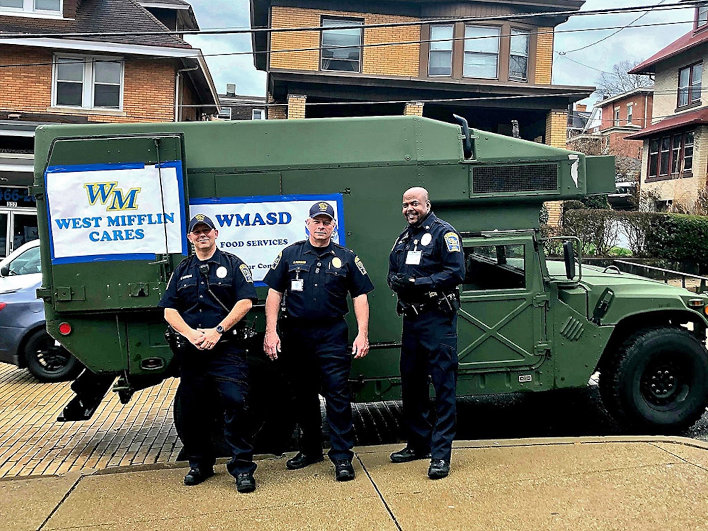 Police officers pose in front of a surplus military truck they received.