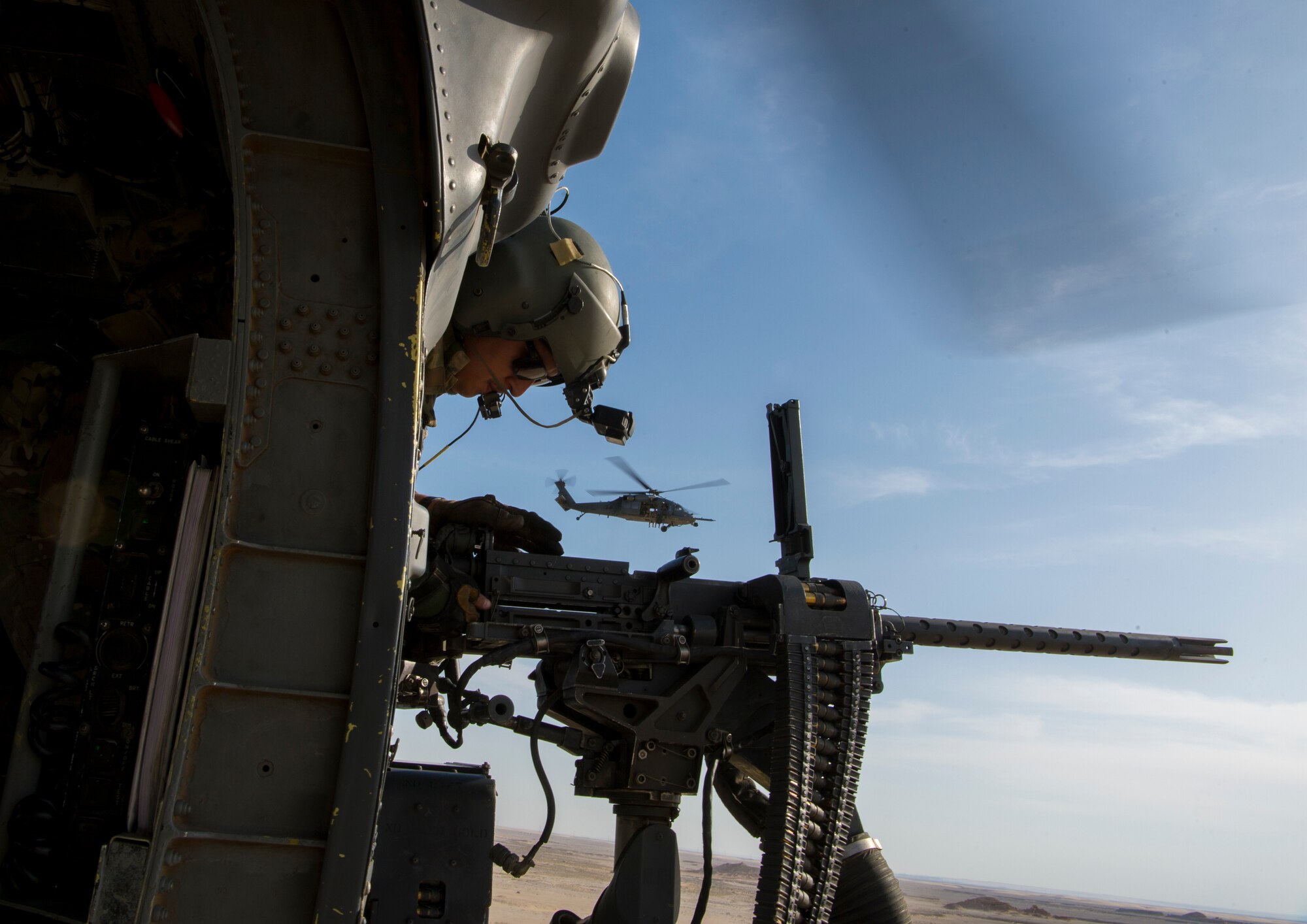 A U.S. Air Force special mission aviator assigned to the 66th Expeditionary Rescue Squadron clears a weapon malfunction inside a HH-60G Pave Hawk during a training exercise near Al Udeid Air Base, Qatar, March 24, 2020.