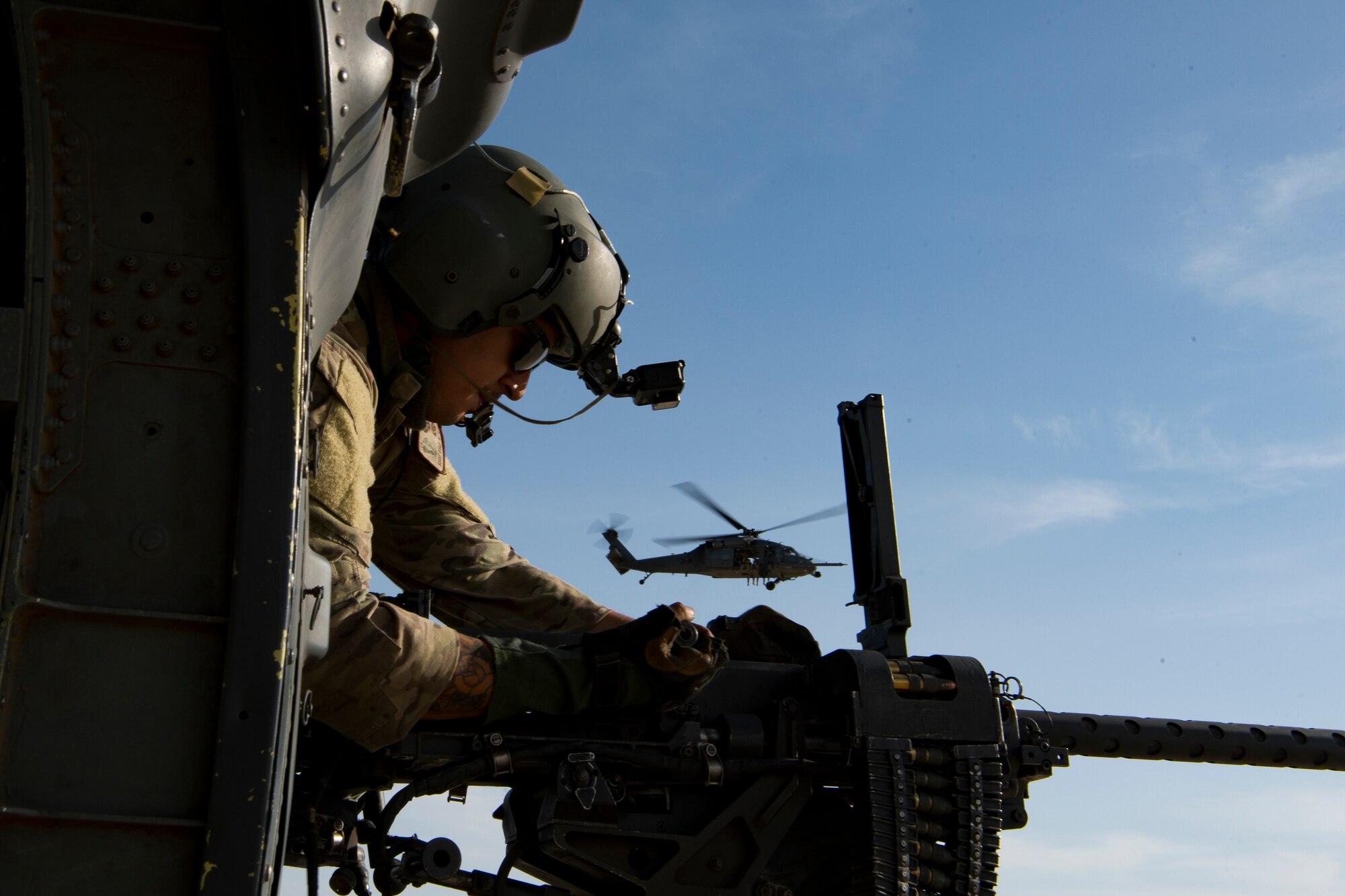 A U.S. Air Force special mission aviator assigned to the 66th Expeditionary Rescue Squadron clears a weapon malfunction inside a HH-60G Pave Hawk during a training exercise near Al Udeid Air Base, Qatar, March 24, 2020.