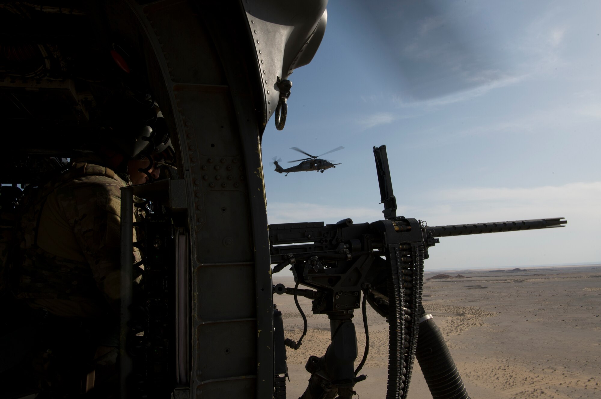 A U.S. Air Force special mission aviator assigned to the 66th Expeditionary Rescue Squadron clears a weapon malfunction inside a HH-60G Pave Hawk during a training exercise near Al Udeid Air Base, Qatar, March 24, 2020.