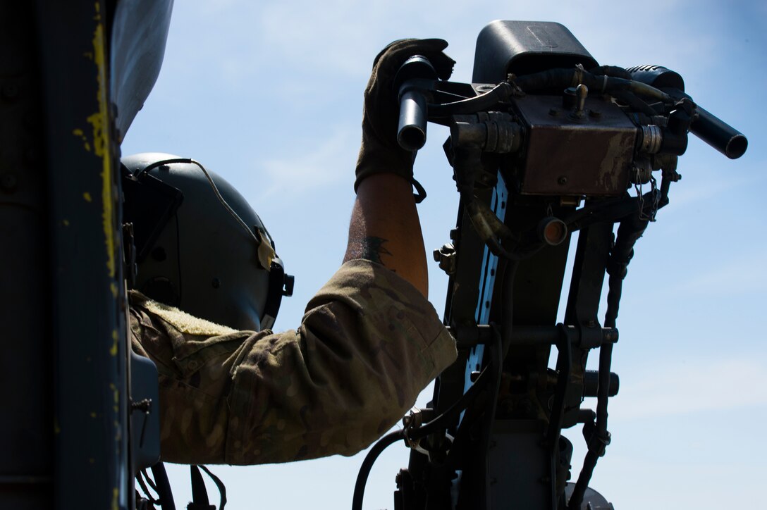 A U.S. Air Force special mission aviator assigned to the 66th Expeditionary Rescue Squadron scans the horizon from inside a HH-60G Pave Hawk during a training exercise near Al Udeid Air Base, Qatar, March 24, 2020.