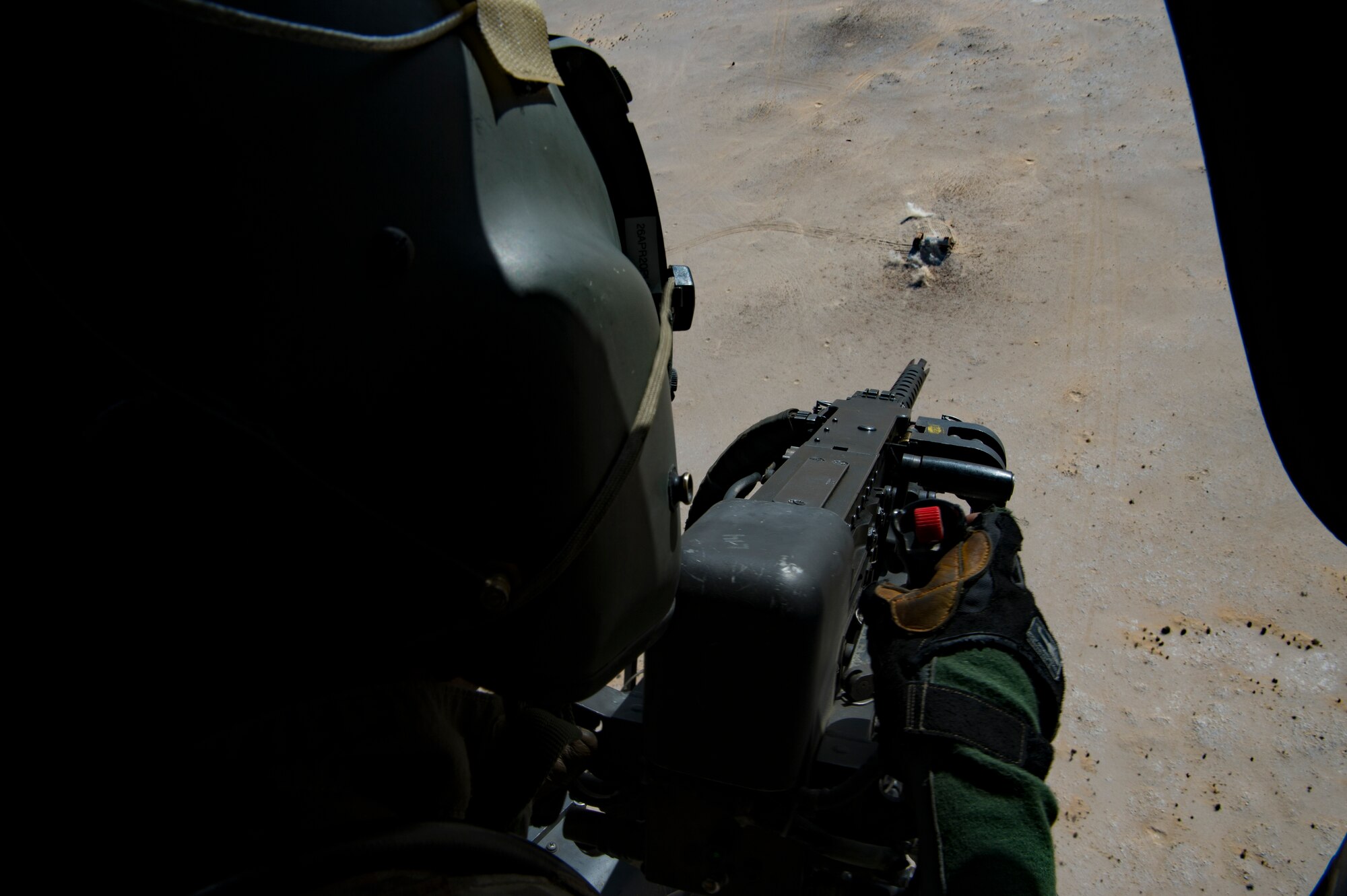 A U.S. Air Force special mission aviator assigned to the 66th Expeditionary Rescue Squadron fires towards a target from a HH-60G Pave Hawk at Al Udeid Air Base, Qatar, March 24, 2020.