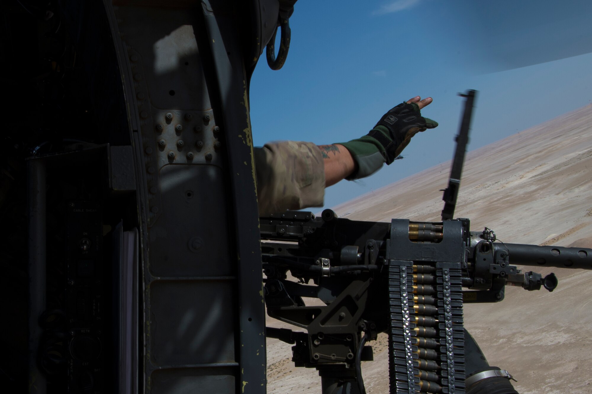 A U.S. Air Force special mission aviator assigned to the 66th Expeditionary Rescue Squadron clears a weapon malfunction inside a HH-60G Pave Hawk during a training exercise near Al Udeid Air Base, Qatar, March 24, 2020.
