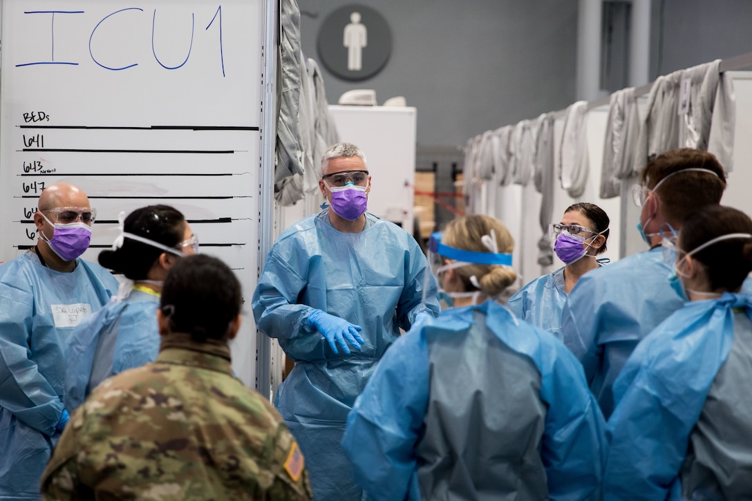 A group of doctors wearing medical gowns and masks stand together in a hospital.