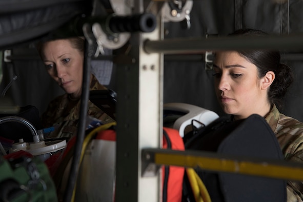 Capt. Tawnie Robert, 34th Aeromedical Evacuation Squadron flight nurse, and Staff Sgt. Cristina Tust, 34 AES aeromedical evacuation technician, set up medical equipment for a training mission on a C-130 Hercules, April 6, 2020 at Peterson Air Force Base, Colorado. The 34 AES reservists conducted an aeromedical training to maintain their skills in providing critical care to patients before and while in flight. (U.S. Air Force photo by Staff Sgt. Tiffany Lundberg)