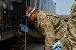 U.S. Air Force Tech. Sgt. Quincy Moore, 8th Logistics Readiness Squadron fuels laboratory NCO in charge, performs a monthly sediment and water test on a refueling unit using an inline sampler at Kunsan Air Base, Republic of Korea, April 3, 2020. These inline samplers are used to grab the sample to verify the fuel quality. (U.S. Air Force photo by Senior Airman Jessica Blair)