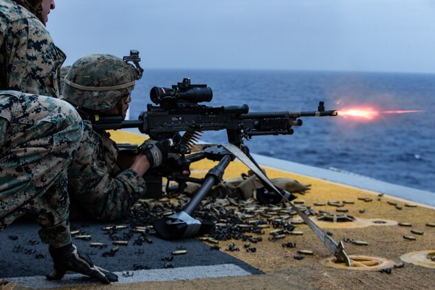 A Marine fires an M240B medium machine gun during a full mission profile defense of the amphibious task force exercise aboard amphibious assault ship USS America (LHA 6).