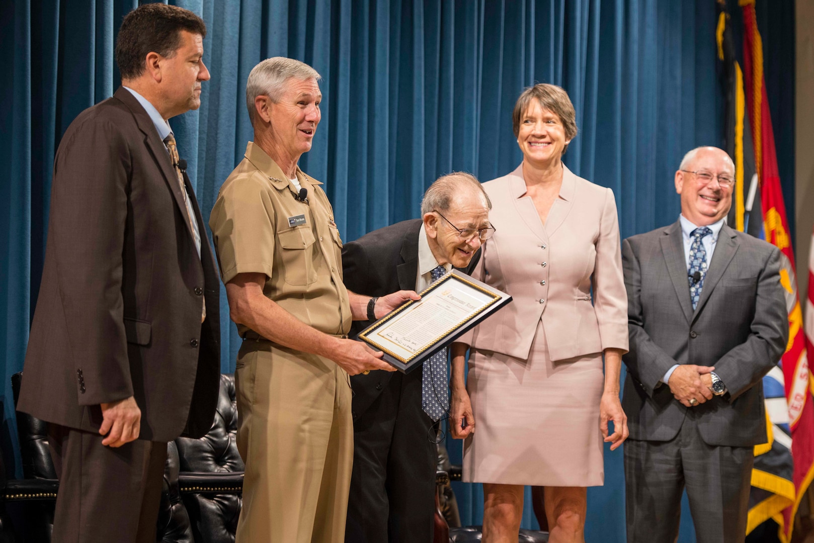 Sarkis Tatigian (center) receives an award during a celebration of his 75 years of federal service from Vice Adm. Thomas Moore, commander, Naval Sea Systems Command (NAVSEA), center left, at the Washington Navy Yard. Tatigian enlisted in the Navy in 1943 and currently serves as the associate director of small business programs at NAVSEA.