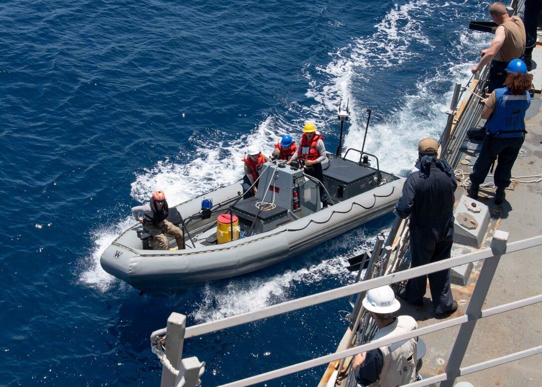 U.S. Navy Sailors assigned to Arleigh Burke-class guided-missile destroyer USS Kidd (DDG 100) depart in a rigid-hull inflatable boat (RHIB)