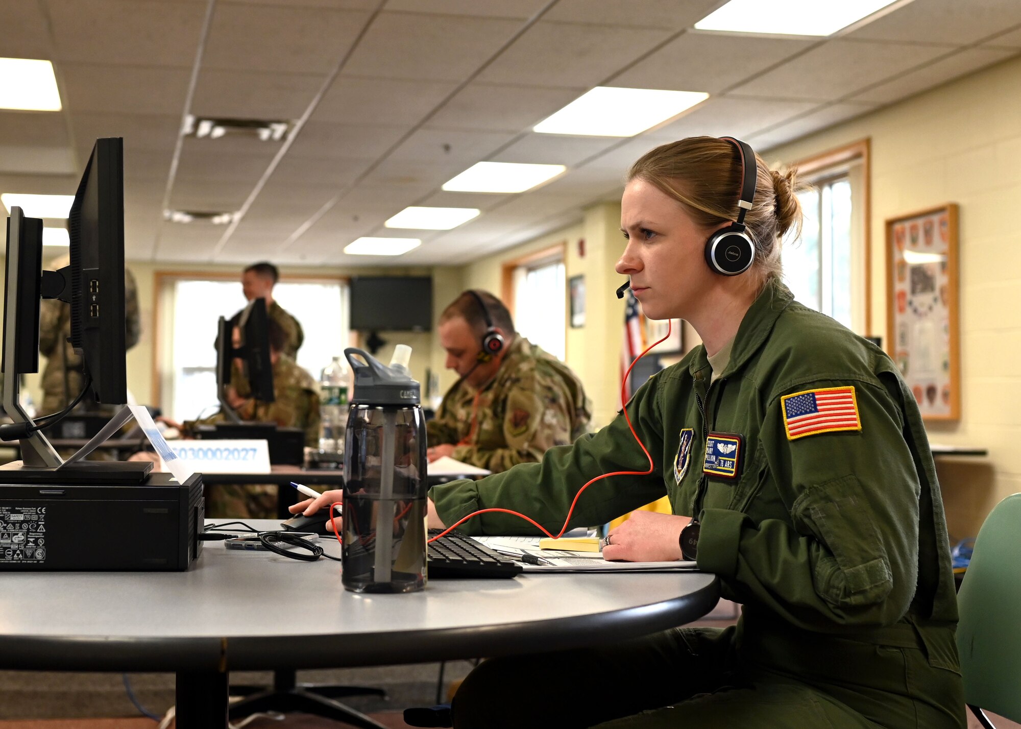 Staff Sgt. Mary Lux, boom operator, 133d Air Refueling Squadron, 157th Air Refueling Wing, New Hampshire Air National Guard, works the phones at a N.H. Employment Security call center at the Richard M. Flynn Fire Academy in Concord, April 2, 2020. The center fields thousands of calls a day in the wake of the COVID-19 crisis, and is staffed with 19 airmen on state active duty seven days a week, 13 hours a day. Photo by Staff Sgt. Charles Johnston, NHNG Deputy State PAO.