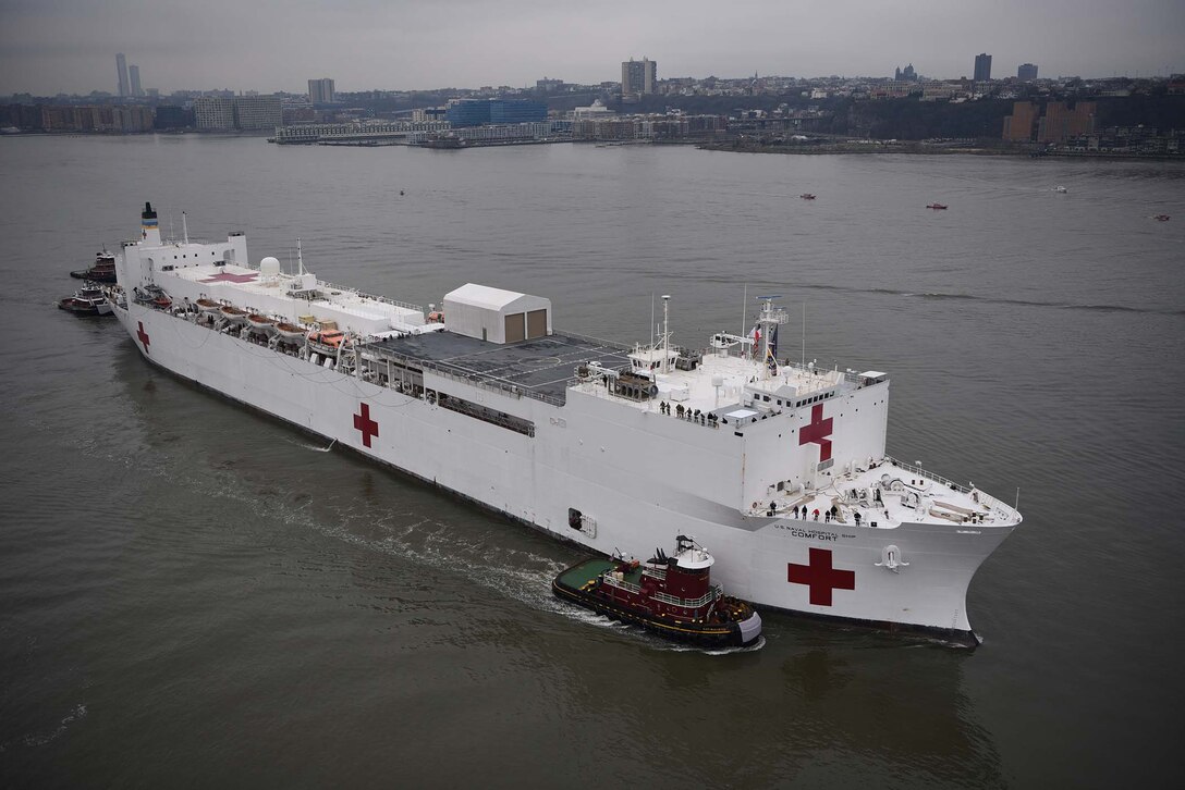 Tugboats assist USNS Comfort up the Hudson River as the hospital ship enters New York City. Federal, state, and local agencies provide a security escort for the patrol. Actions by logistics data experts at the Defense Logistics Agency’s Logistics Information Services will make it easier for the crew to acquire parts for ship. (U.S. Coast Guard photo by Petty Officer 2nd Class Zachary Hupp)