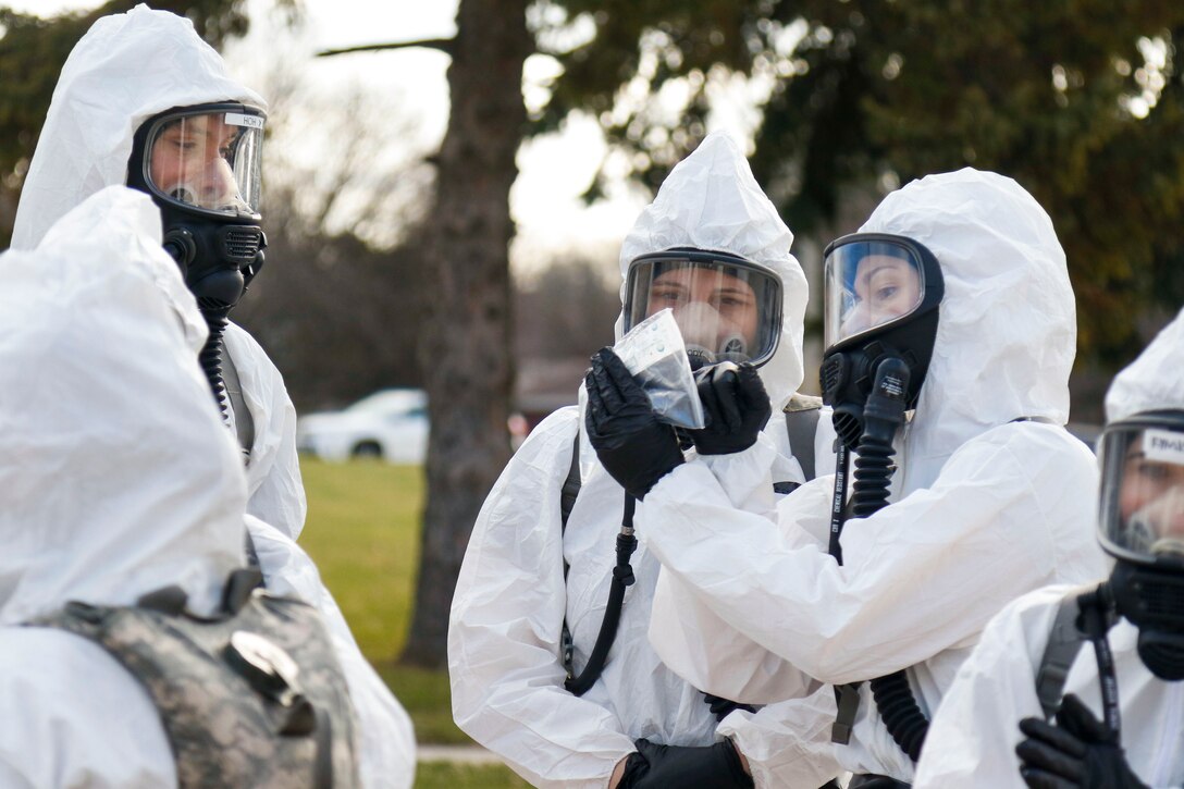 A group of National Guardsmen wearing protective gear stand together.