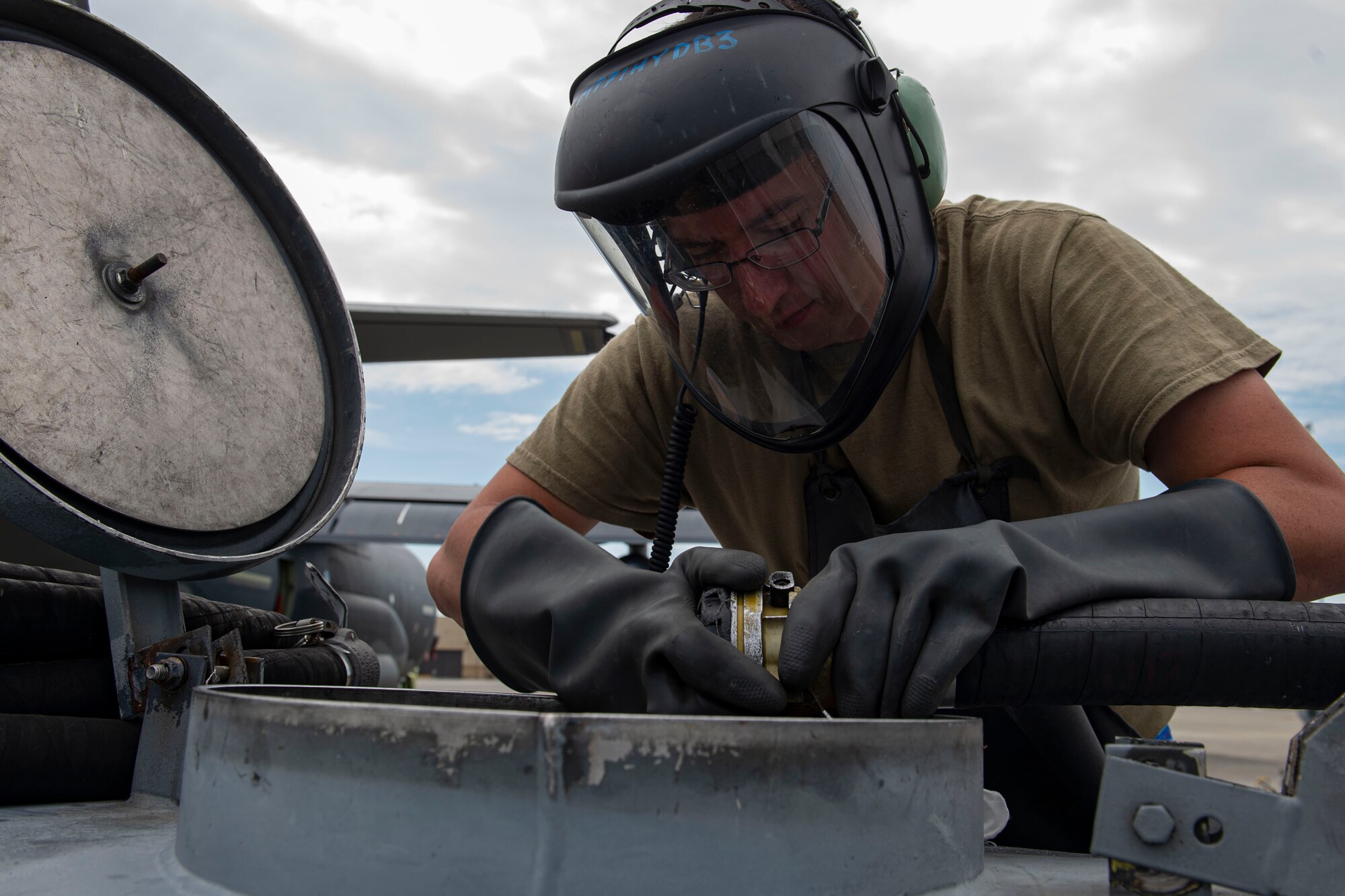Photo of an Airman disconnecting an in-flight refueling hose.