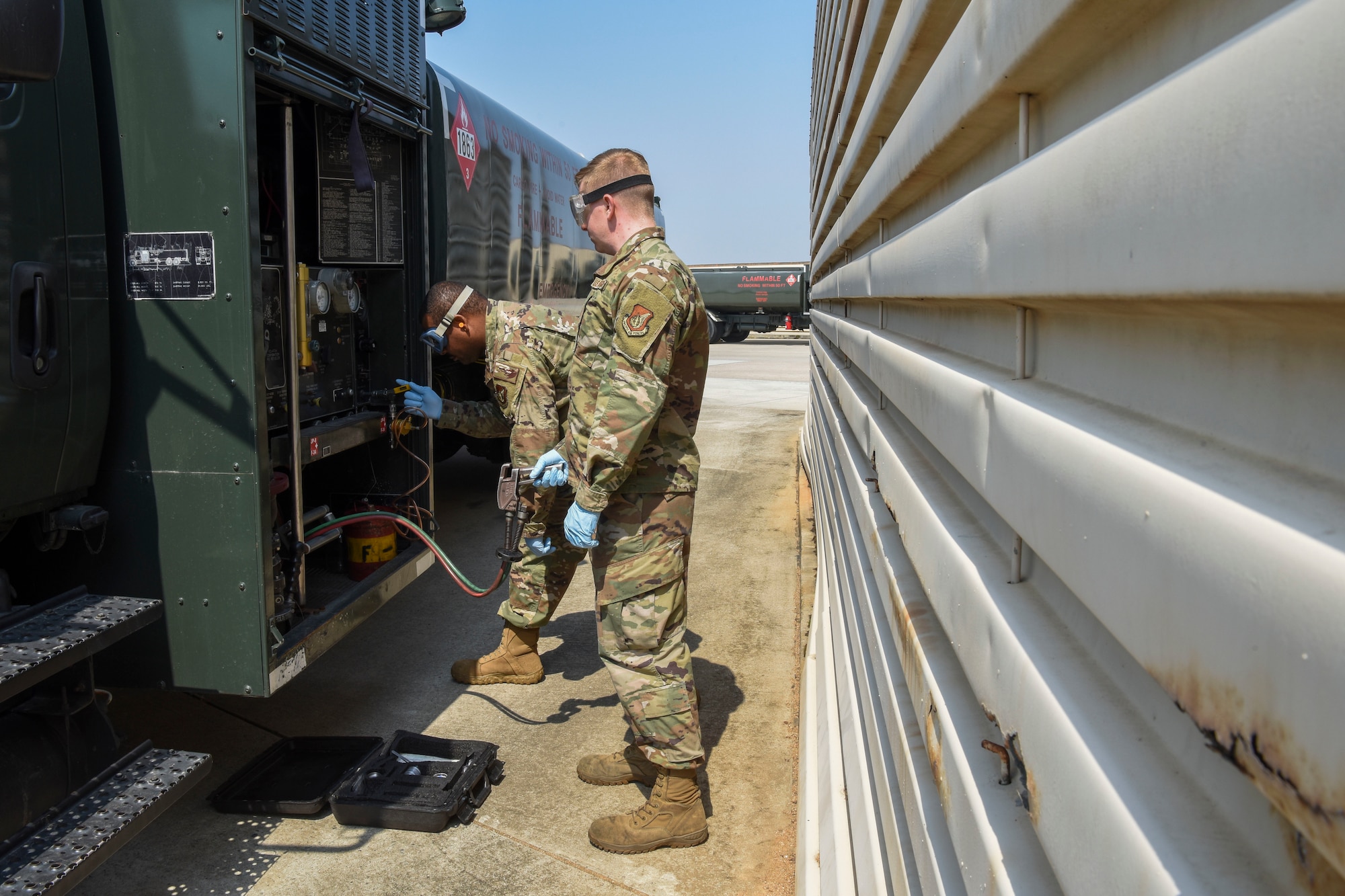 U.S. Air Force Tech. Sgt. Quincy Moore, 8th Logistics Readiness Squadron fuels laboratory NCO in charge, and Senior Airman Cody Lane, 8th LRS fuels laboratory technician, perform a monthly sediment and water test on a refueling unit using an inline sampler at Kunsan Air Base, Republic of Korea, April 3, 2020. These inline samplers are used to grab the sample to verify the fuel quality. (U.S. Air Force photo by Senior Airman Jessica Blair)