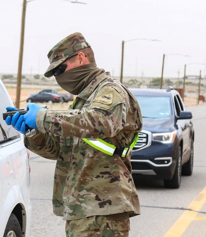 Soldier wears a face mask and gloves as protection.