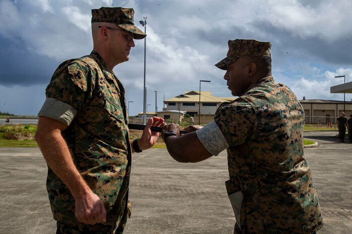 U.S. Marine Corps Sgt. Maj. Juarice Collins, off-going sergeant major, Marine Corps Air Station Kaneohe Bay, passes the sword of office to Lt. Col. Tyler Holland, commanding officer, MCAS, during the MCAS relief and appointment ceremony, Marine Corps Base Hawaii, March 27, 2020. Sgt. Maj. Juarice Collins relinquished responsibilities to Sgt. Maj. Jose Romero. Collins retired after 23 years of honorable and faithful service. (U.S. Marine Corps photo by Cpl. Matthew Kirk)