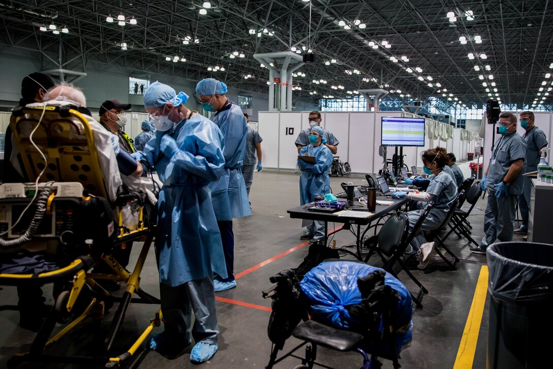 Persons in hospital scrubs interact with a patient.