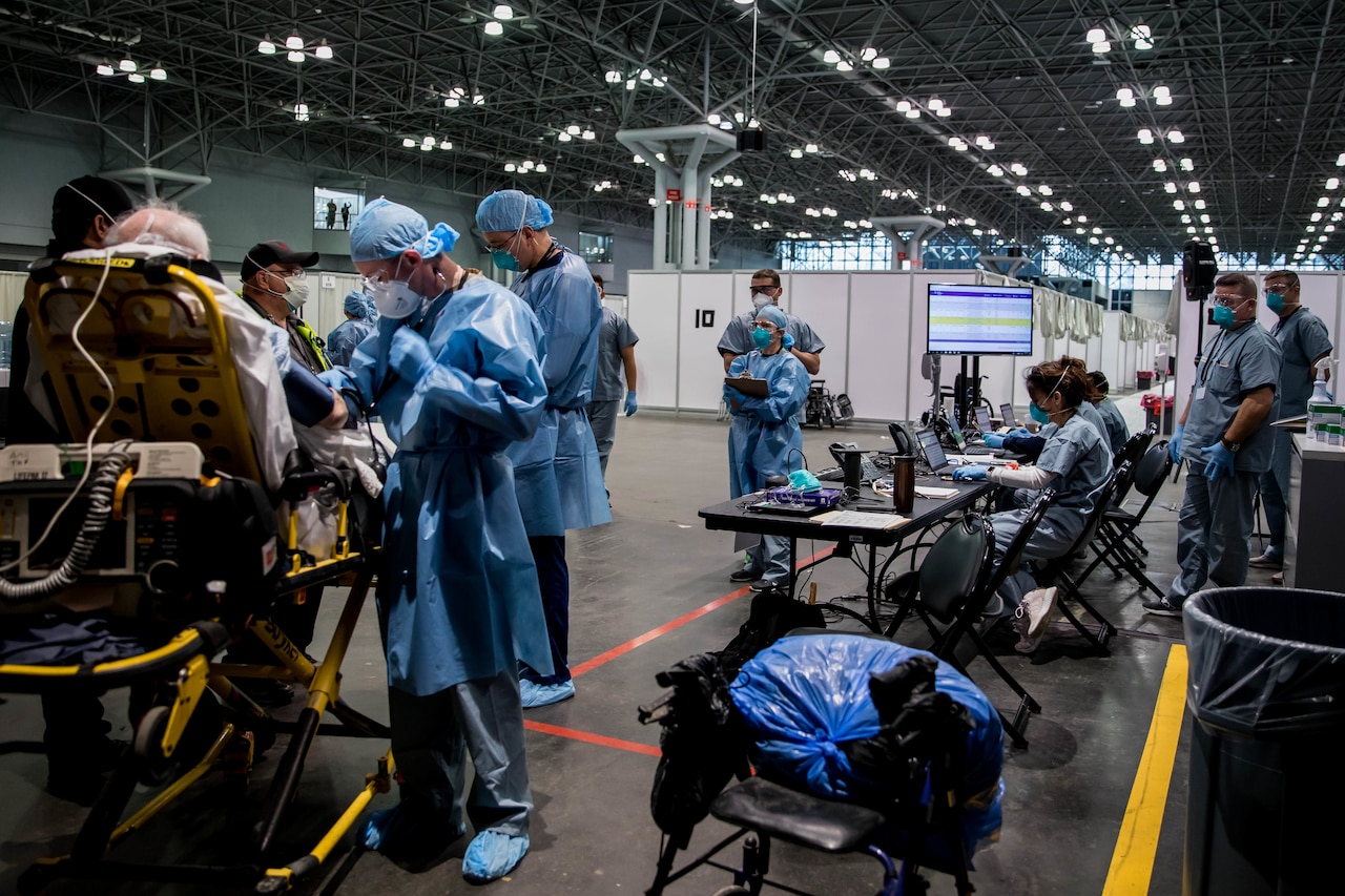 Persons in hospital scrubs interact with a patient.