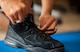 Staff Sgt. Kevin ties his black shoes on a blue work out mat inside his home in Las Vegas.