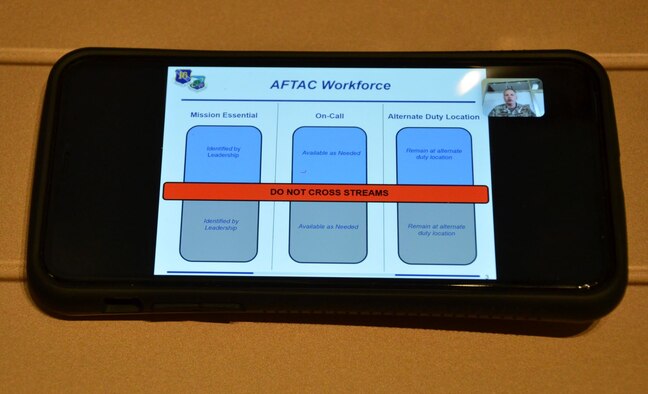 Col. Chad Hartman, commander of the Air Force Technical Applications Center, Patrick AFB, Fla., is seen via videochat (top right) April 3, 2020 as he conducts a tele-Town Hall meeting with his command chief, Chief Master Sgt. Amy Long for members of the nuclear treaty monitoring center and their family members to discuss COVID-19 response efforts.  (U.S. Air Force photo by Susan A. Romano)