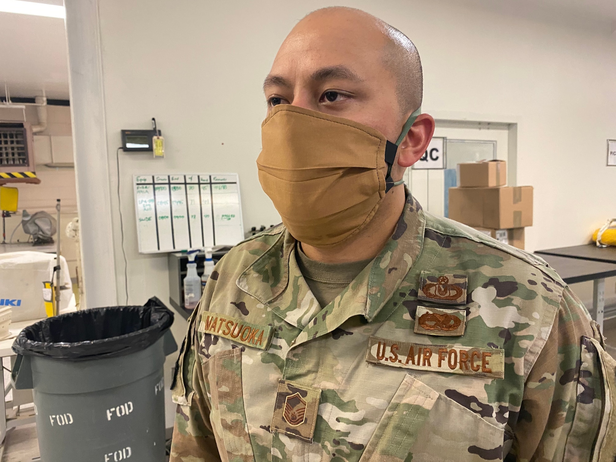 Master Sgt. Henry Matsuoka, section chief, air crew flight equipment, 412th Operations Support Squadron, 412th Operations Group, 412th Test Wing, demonstrates proper use of a mask that was fabricated using available equipment in the Air Crew Flight Equipment section at Edwards Air Force Base, April 7. Although cloth masks don’t offer full protection from COVID-19, the CDC advises that a simple cloth covering can slow the spread of the virus and help people who may have the virus and not know it from spreading it to others. (Courtesy photo)