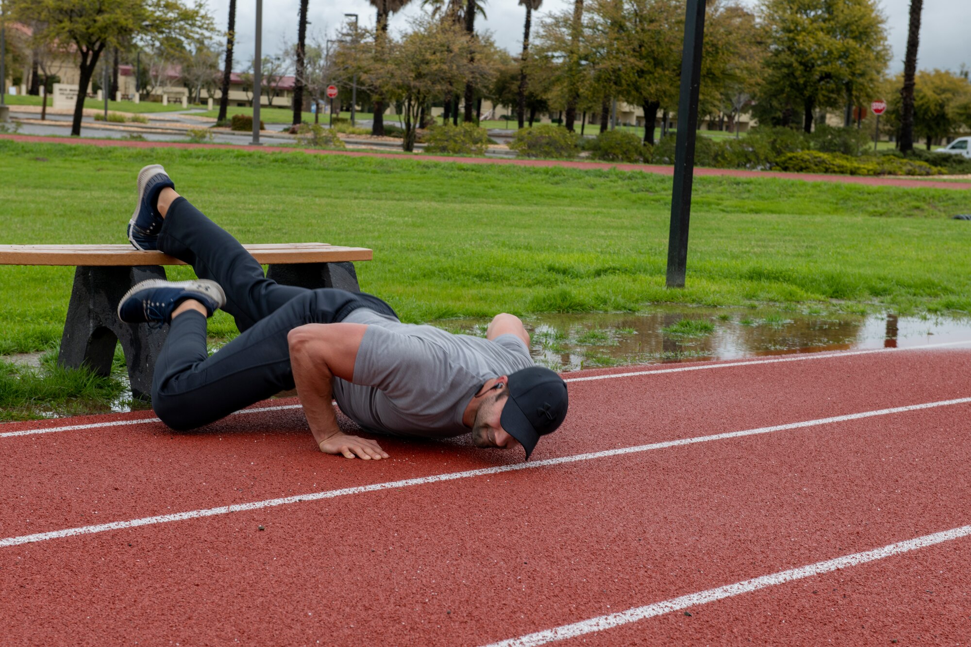 An Airman is doing push ups on a track.