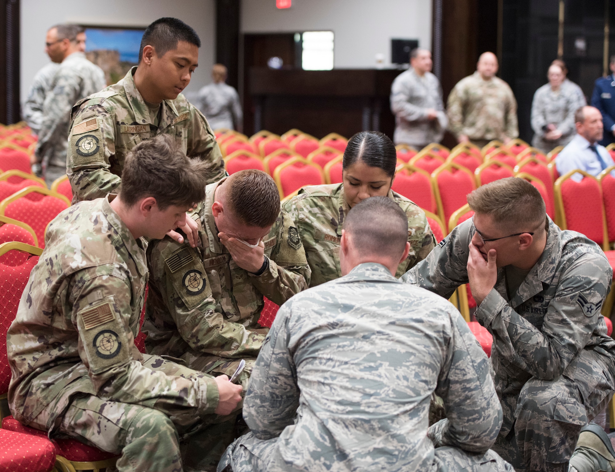 Airmen comfort each other during a memorial service for a colleague who committed suicide, Incirlik Air Base, Turkey, May 17, 2019. Since 2019, the Air Force has accelerated efforts to combat the suicide crisis among its uniformed and civilian personnel. (U.S. Air Force photo by Staff Sgt. Joshua Magbanua)