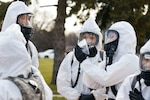 A group of National Guardsmen wearing protective gear stand together.