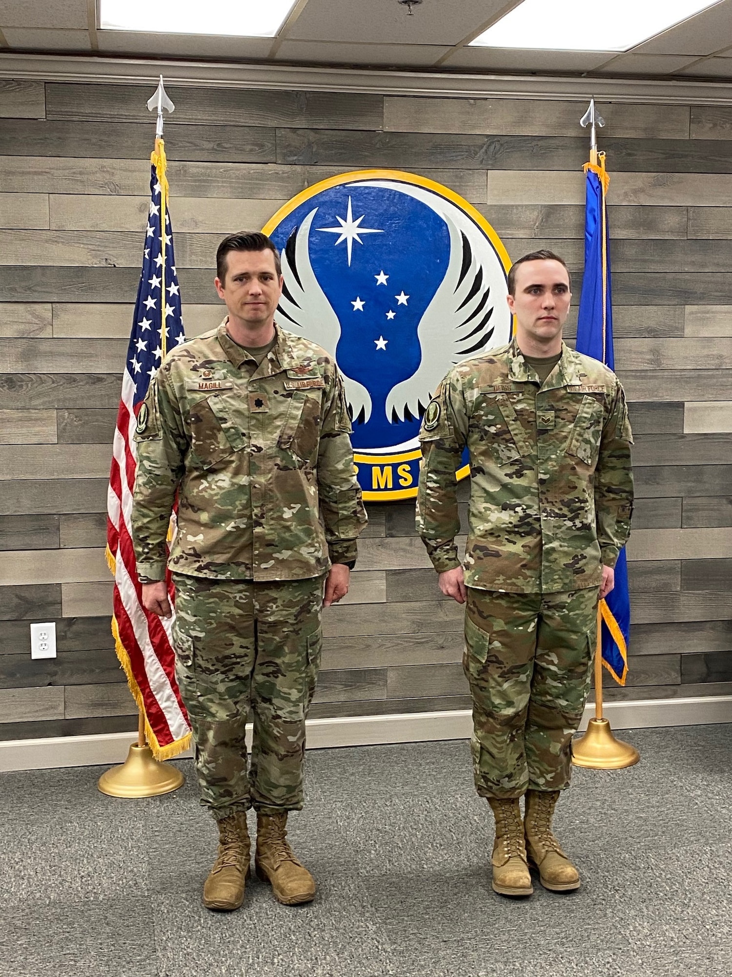 Photo of two individuals at attention during a promotion ceremony.