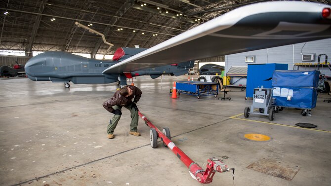 Maj. Marc Nichols, 452nd Flight Test Squadron Assistant Director of Operations, conducts a walk-through inspection of an RQ-4 Global Hawk remotely-piloted aircraft at Edwards Air Force Base, California, April 6. (Air Force photo by Giancarlo Casem)