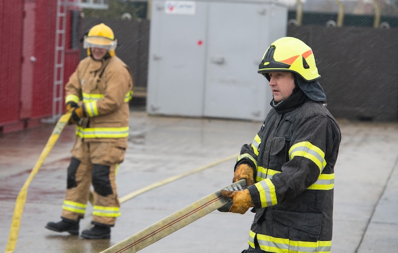 Firefighters with the 423rd Civil Engineer Squadron roll up a firehose during confined spaces training at RAF Alconbury, England on March 30, 2020. This type of training helps the firefighters maintain readiness and stay proficient in their craft. (U.S. Air Force photo by Master Sgt. Brian Kimball)