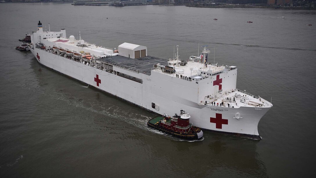 Tugboats assist USNS Comfort up the Hudson River