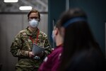 New Jersey Air National Guard Capt. Sara Kucharski, a physician assistant with the 108th Medical Group, briefs civilian volunteers arriving at the field medical station (FMS) at the Meadowlands Exposition Center, Secaucus, N.J., April 6, 2020. The New Jersey National Guard medical staff is helping state and local officials operate the FMS in a COVID-19 relief effort.