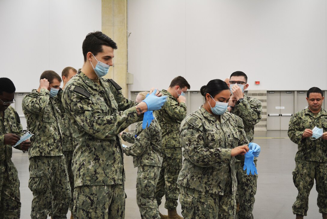 Navy personnel conduct personal protection equipment training during COVID-19.