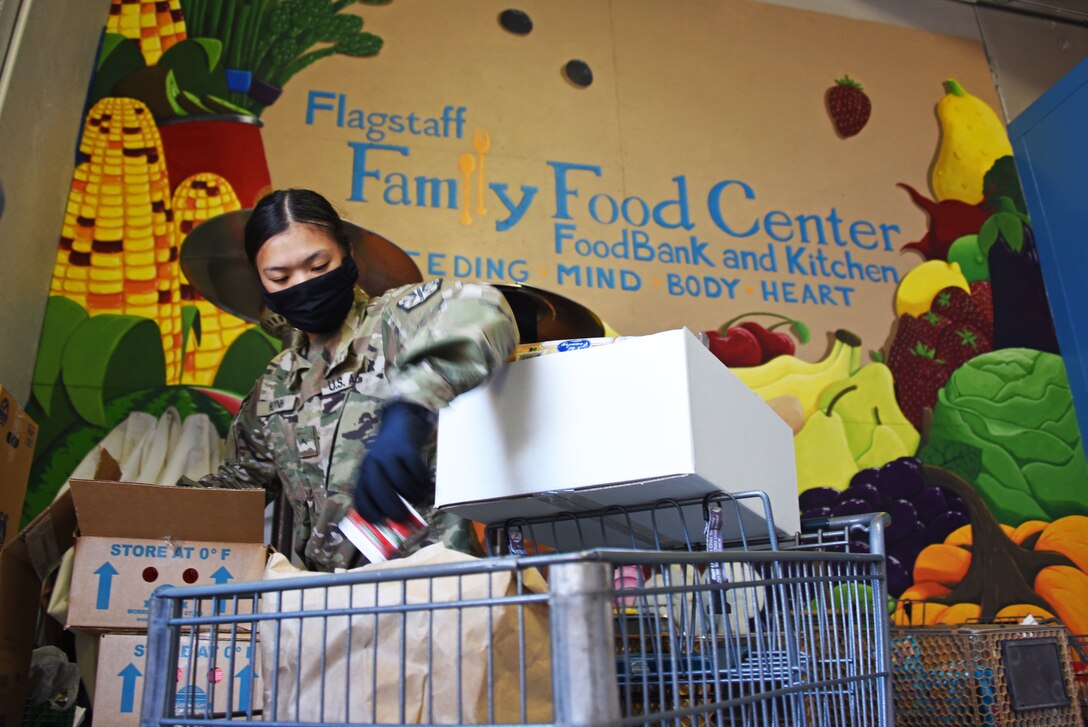 Guardsman prepares boxes of fresh produce and groceries for distribution.