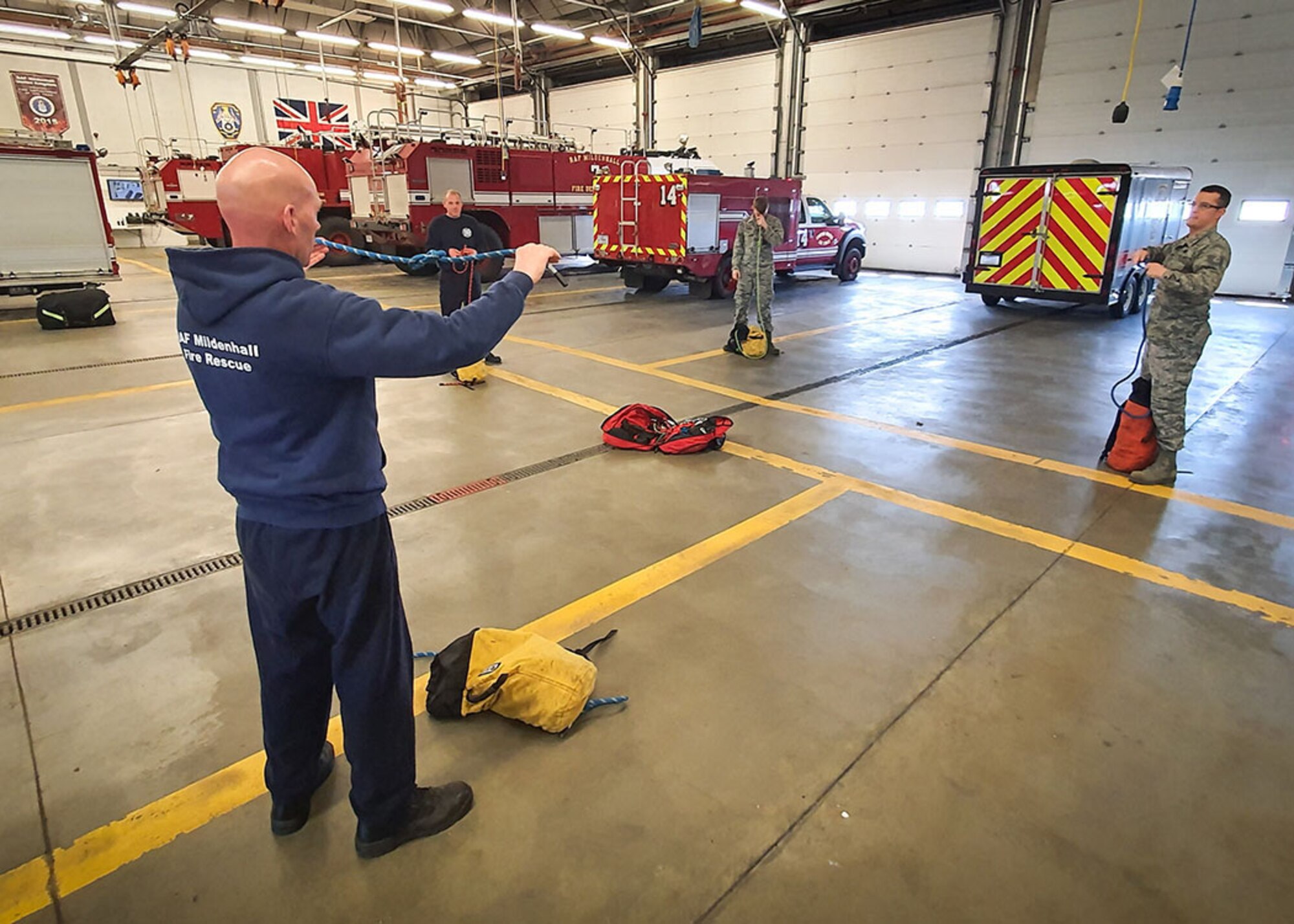 U.S. Air Force and civilian firefighters from the 100th Civil Engineer Squadron Fire Department carry out a rescue rope inspection while practicing physical distancing April 7, 2020, at RAF Mildenhall, England. During the COVID-19 lockdown, the firefighters are taking extra precautions both in and out of the fire station to ensure the health and safety of both themselves and the base community. (Courtesy photo by Matthew Thorpe)