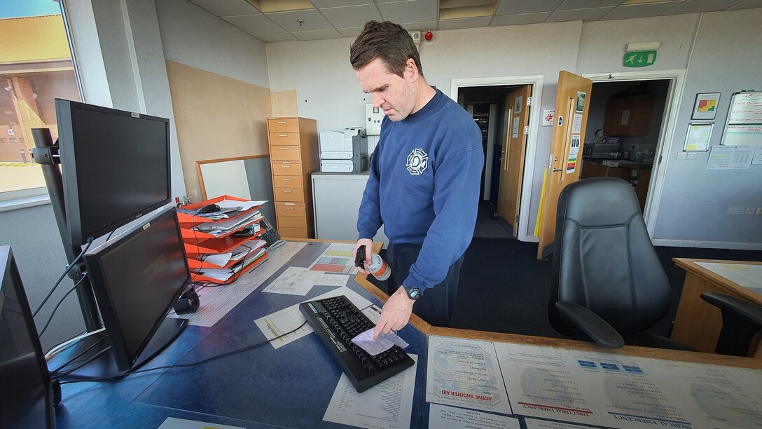 Crew Manager James Greenaway, 100th Civil Engineer Squadron Fire Department crew chief, disinfects equipment in the emergency control center April 7, 2020, at RAF Mildenhall, England. As part of the extra health and safety measures during this time of a pandemic, the firefighters disinfect and sanitize all equipment and areas around the fire station while practicing physical distancing. (Courtesy photo by Matthew Thorpe)