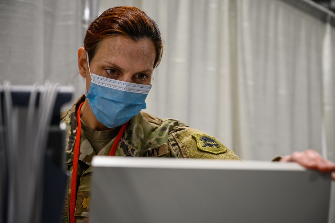 A military officer stares intently at a screen.