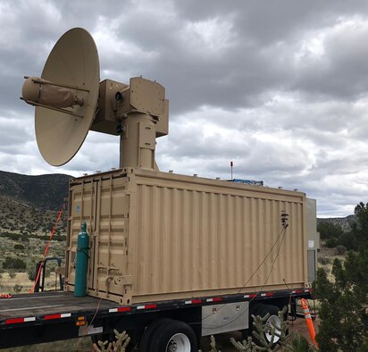 photo of military laser dish on top of shipping container