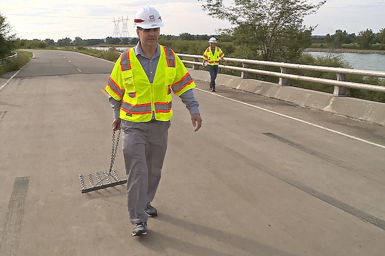 Lyle Peterson, civil engineer, U.S. Army Corps of Engineers, Omaha District, drags a chain across one of the bridges at the Big Bend Dam near Fort Thompson, S.D. Chaining allows bridge inspectors to determine whether or not there are any underlying problems beneath the surface of the bridge which require repairs to keep the bridge safe and operational.