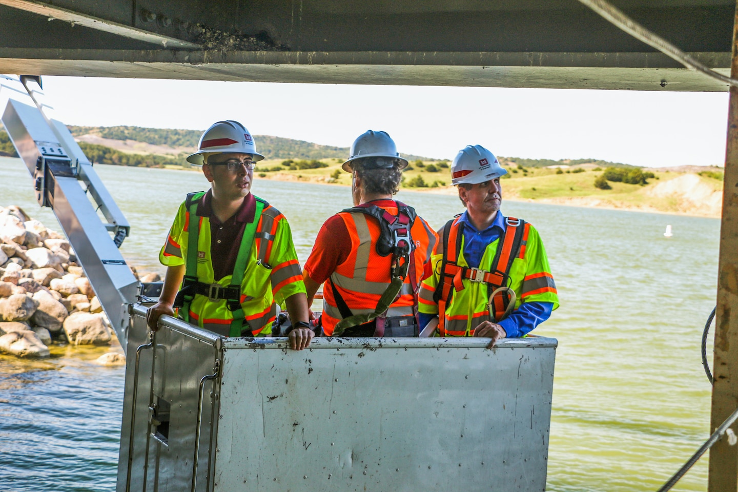 Narturi Narisco, left, and Lyle Peterson, civil engineers, U.S. Army Corps of Engineers, Omaha District, hang above the Missouri River in a snooper to inspect the underside of one of the bridges at the Big Bend Dam near Fort Thompson, S.D.