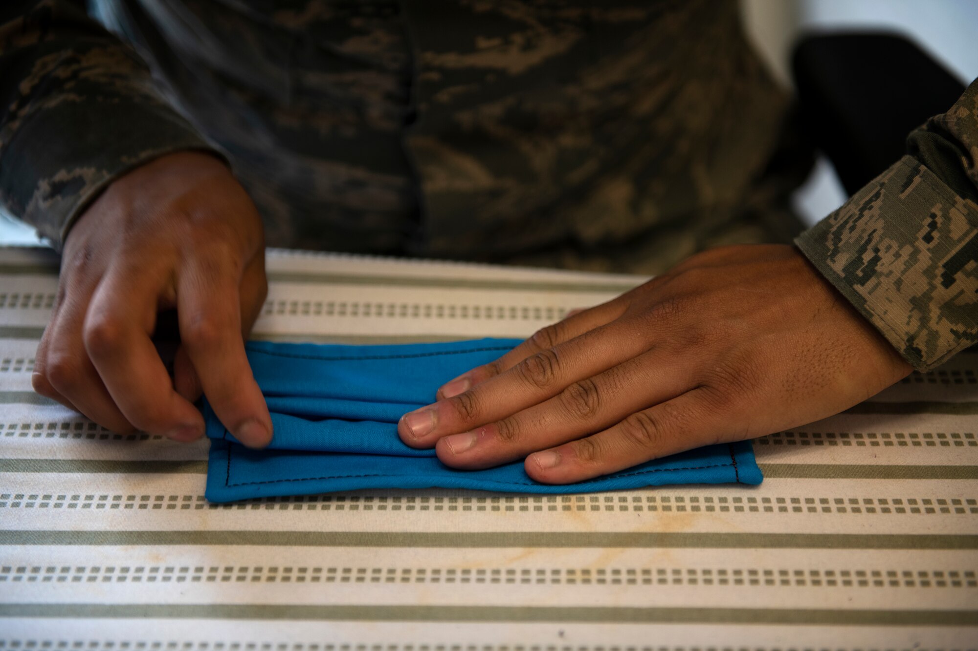 ALTUS AIR FORCE BASE, Okla. - U.S. Air Force Airman First Class Luis Mora, an Air Crew Flight Equipment (AFE) apprentice assigned to the 97th Operations Support Squadron, folds face masks for base members, April 6, 2020 at Altus Air Force Base Oklahoma.