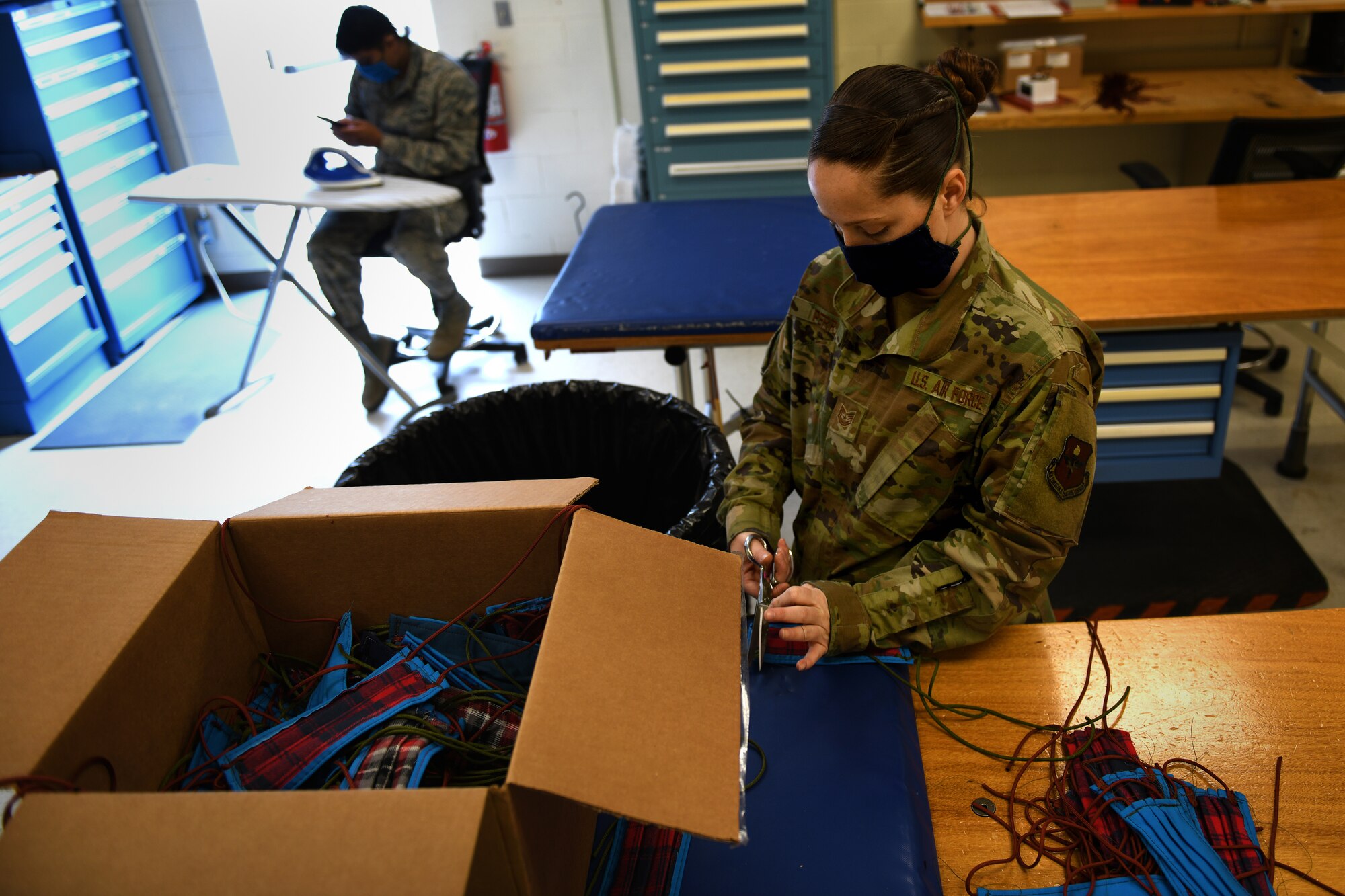 ALTUS AIR FORCE BASE, Okla. – U.S. Air Force Tech. Sgt. Skye Perry, an Air Crew Flight Equipment (AFE) craftsman assigned to the 97th Operations Support Squadron, trims threads off of face masks for base members, April 6, 2020 at Altus Air Force Base Oklahoma.