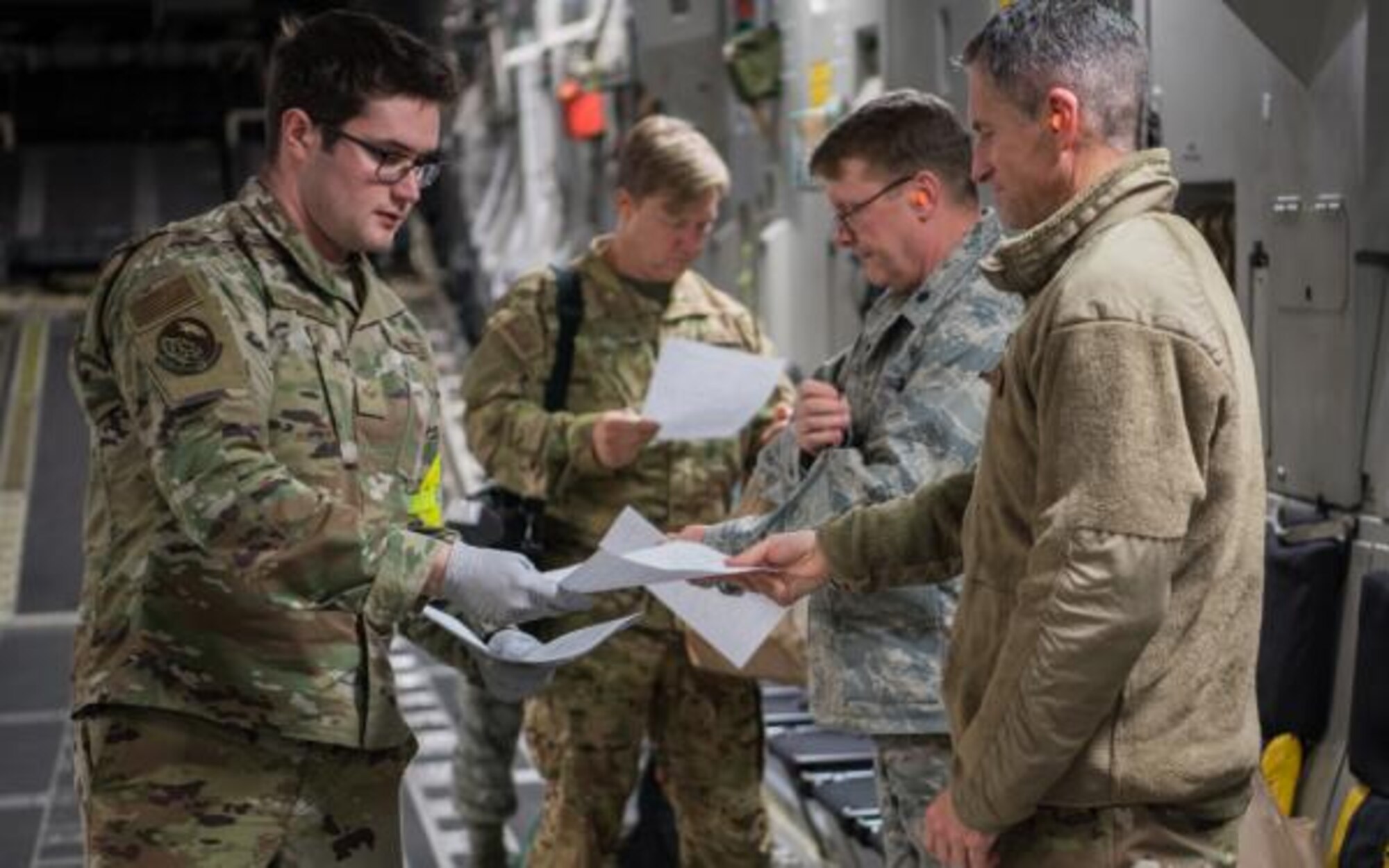 MLS- Lt. Col. William M. Lucas, 940th AMDS commander and flight surgeon and Lt. Col. Patrick L. Keller, SGP, wait in turn to have their papers reviewed before existing the aircraft to be transported to Nw York.