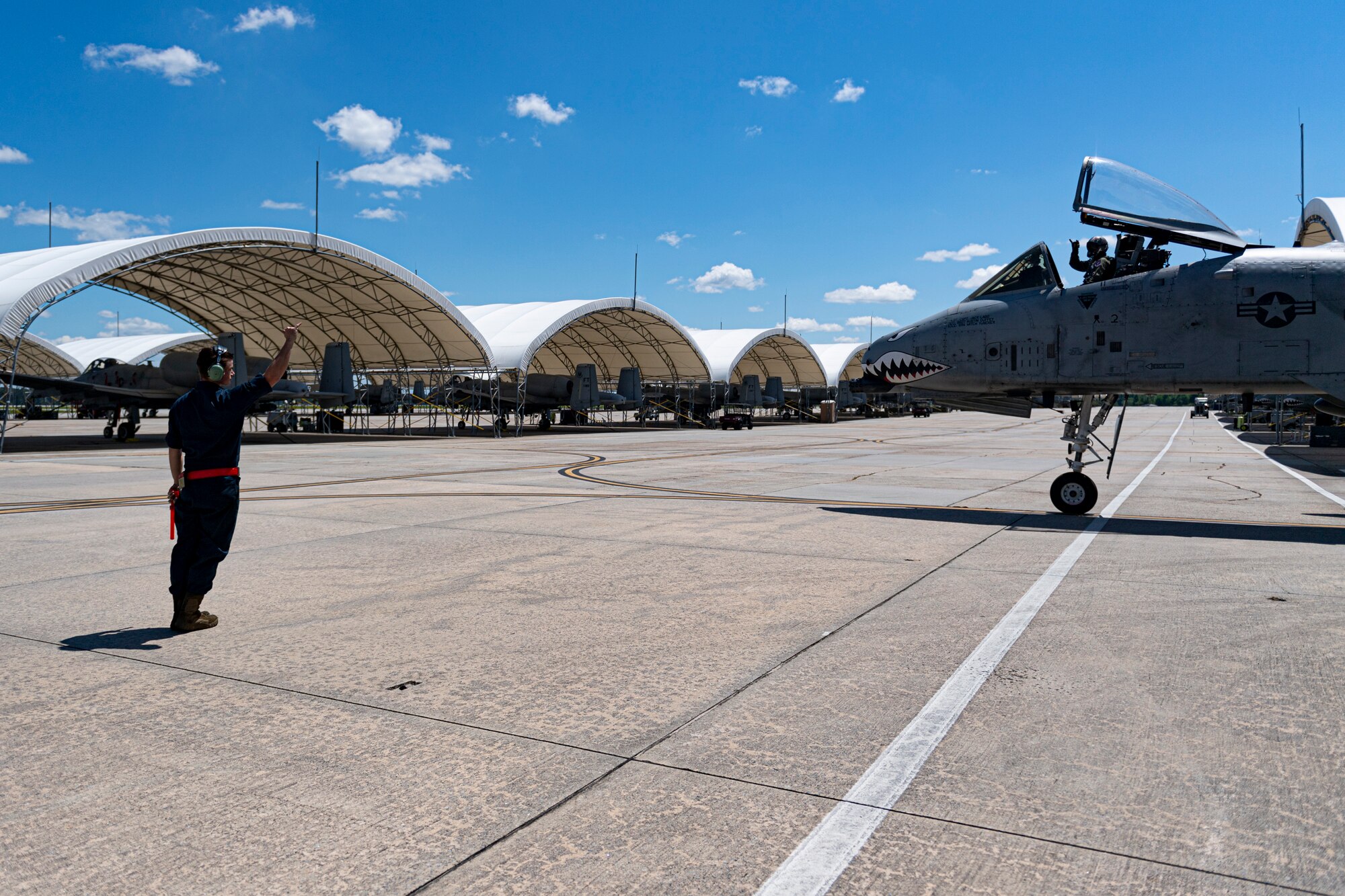 A photo of an Airman waving to a pilot