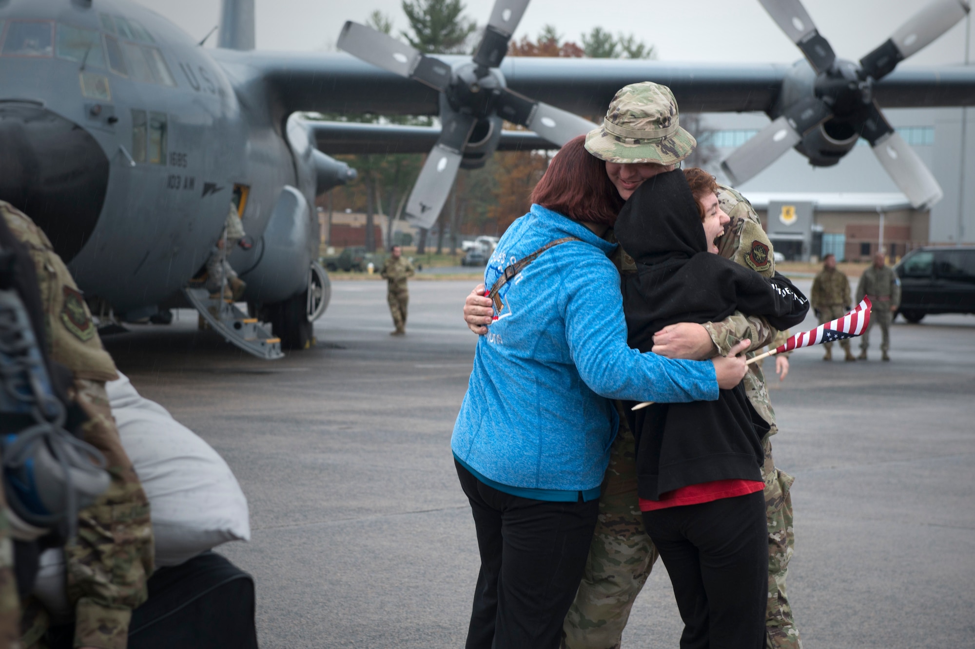 an airman hugs his family